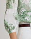 Close-up of model wearing the Flora Blouse In Tropical Green, featuring a dropped shoulder, puffed 3/4 length sleeves, gathered above the elbow and narrow cuffs.