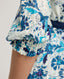 Close-up of model wearing our Ivy Tea Dress in a fine blend of silk and cotton, featuring a puff sleeve detail.