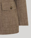 Close-up on pocket detail on Brown textured jacket with on light gray background