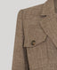 Close-up of a brown textured blazer with a button on a light gray background