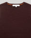 Brown sweater with a brand label on a gray background