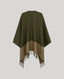 An olive green and beige color-blocked cape with fringe trim, shown from the back against a solid light gray background.