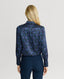 Back of Model wearing the Birch Print Silk Detachable Tie Neck Blouse in Midnight Blue with navy trousers 
