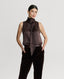 Model wearing sleeveless silk blouse with neck tie in chocolate brown with brown velvet trousers 