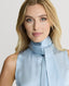 Close-up of Model wearing a Ice blue silk sleeveless top with a neck tie detail 