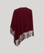 Burgundy poncho with fringe details on a light gray background