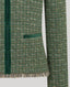Green boucle fabric with velvet trims on a light gray background