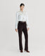 Model wearing Cliveden Silk Fixed Tie Neck Blouse in Winter Ivory with flare trousers 