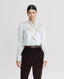 Model wearing Cliveden Silk Fixed Tie Neck Blouse in Winter Ivory 