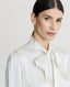 Close-up on Model wearing Cliveden Silk Fixed Tie Neck Blouse in Winter Ivory 