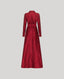 A long-sleeved, floor-length red dress shown from the back, featuring a matching waist belt, on a solid light gray background.