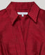 A close-up of a red collared button-up shirt with a textured, crinkled fabric finish. The brand label 'REALLY WILD CLOTHING' is visible inside the collar.