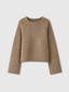A cropped, long-sleeve knit sweater in a warm camel brown color, featuring raglan sleeves and ribbed cuffs and hem, shown against a light gray background.