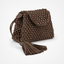 A brown textured leather clutch bag with a flap closure, a matching leather tassel, and a woven beaded strap detail, shown on a clean white background.