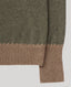 Close-up of a knit sweater showing a dark olive green body with a contrasting ribbed cuff in a warm taupe-brown color, set against a solid light gray background.