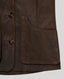 Close-up of a dark brown leather jacket showing a front button closure and a large front patch pocket, set against a light gray background.