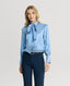 Model wearing the Glyndebourne Silk Detachable Tie Neck Blouse in Cornflour Blue with navy trousers 