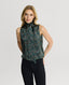 Model wearing sleeveless silk tie neck blouse in Loden Green and oxblood red 