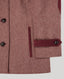 Close-up of a tweed jacket in dusty rose-brown with dark buttons and a contrasting burgundy pocket flap detail, shown on a light gray background.
