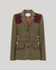 A tailored tweed blazer with a brown and beige windowpane pattern, contrasting dark burgundy velvet shoulder panels, a matching waist belt, and flap pockets, shown on a neutral gray background.