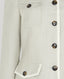 Close-up of a light sage green jacket with buttons on a white background