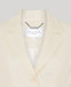 Cream-colored blazer with 'Really Wild London' label against a white background