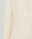 Close-up of a cream-colored blazer on a light gray background