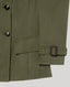 Close-up of a sage green jacket showing the sleeve with a matching belt buckle detail, a front flap pocket, and dark buttons against a light gray background.