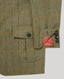 Close-up of a tweed jacket or blazer in olive green with a subtle windowpane check pattern in muted blue, orange, and red lines. The fabric shows a herringbone weave texture, with a flap pocket and button closure visible on the left side, and the cuff with dark buttons and a small orange pocket detail on the right side.