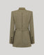 A structured wool-blend coat shown from the back, featuring a high stand collar, a central vertical arrow motif, a matching waist belt, and button details on the cuffs, in a muted olive-tan tweed pattern.
