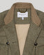 Close-up of a double-breasted herringbone jacket with a tan suede-like collar and a cream-colored interior lining. The brand label 'REALLY WILD LONDON' is visible inside the collar.