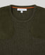 Close-up of a ribbed knit sweater in dark olive green with contrasting solid dark green suede-like shoulder panels and a bright orange inner collar trim. A white neck label reads REALLY WILD CLOTHING.