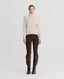 Model wearing Lambswool High-Neck Sweater in Swansdown Ivory with brown trousers and brown leather boots 