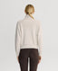 Back of Model wearing Lambswool High-Neck Sweater in Swansdown Ivory showing Fully fashioned rib detail at back neck yoke
