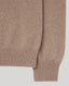 Close-up of a ribbed knit sweater sleeve in a warm taupe-brown color, showing the fine knit texture and ribbed cuff against a light gray background.