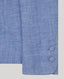 Close-up of a blue textured fabric with covered buttons on a light grey background
