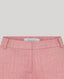 Close-up of pink pants with a brand label on a light gray background
