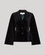 A black velvet cape with notched lapels, three front buttons, and a peplum waist, displayed against a solid light gray background.