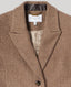 Close-up of a brown and beige herringbone tweed blazer by Really Wild London, showing the collar, interior lining, and a single dark button.