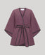 A mauve-purple wrap poncho-style coat with black trim and a matching waist tie, shown flat against a light gray background.