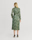 Back of Model wearing Oak Print Silk Shirt Dress With Tassel in Green and Cream with heels 