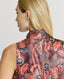 Close-up of Back of Model wearing sleeveless silk blouse with neck tie in coral orange peacock print 