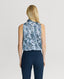 Back of Model wearing sleeveless silk blouse with neck tie in ice blue peacock print with navy trousers 