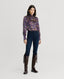 Model wearing Plumage Feather Print Silk Fixed Tie Neck Blouse in Aubergine with jeans and boots 