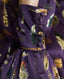 Close-up on covered buttons on the cuff Plumage Feather Print Silk Fixed Tie Neck Blouse in Aubergine with jeans and boots 