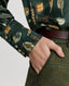 Close-up on covered buttons on the cuff of the Plumage Feather Print Silk Fixed Tie Neck Blouse in green with tweed trousers 