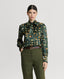 Model wearing Plumage Feather Print Silk Fixed Tie Neck Blouse in green with tweed trousers
