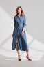 Model wearing a blue linen dress with a belt on a white background