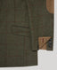 Close-up of a tweed blazer in olive green with a subtle red windowpane check pattern, featuring a tan suede pocket and a buttoned cuff detail.