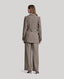 Back of Model wearing Highclere Wool Safari Jacket in Taupe Camel Check 